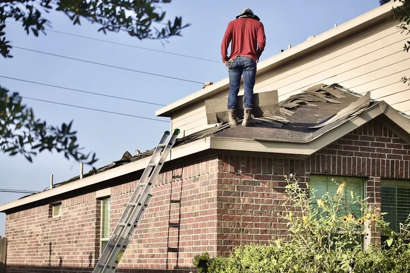 Professional roofer working on a residential roof in Metro West